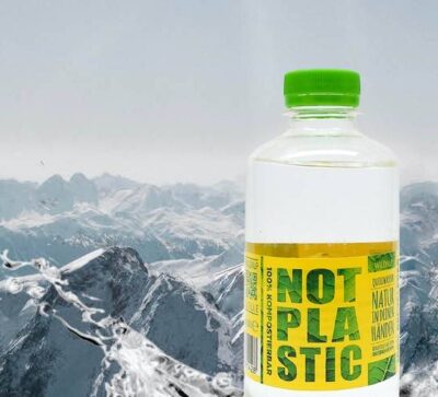 Das NOT PLASTIC WATER von Wildalp vor einer Berglandschaft